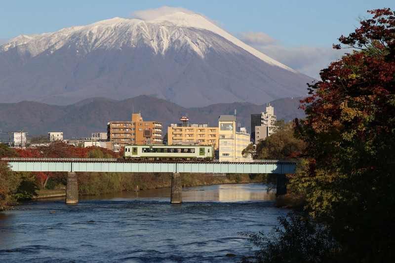 盛岡市内で岩手山をバックに鉄橋を渡る山田線
