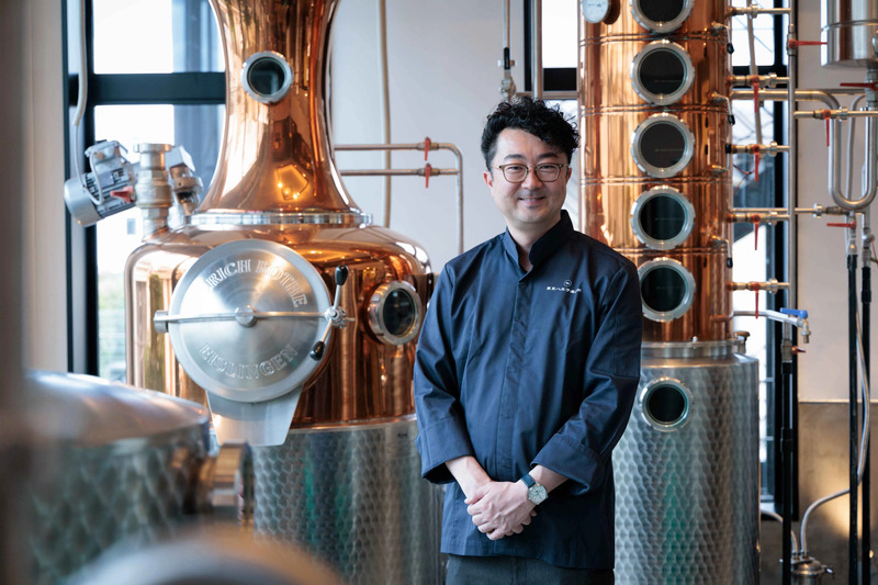 自慢の蒸留器の前に立つ中澤眞太郎さん