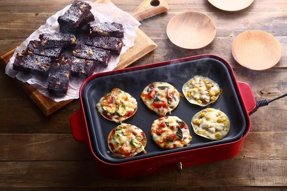 ホットプレートに油を熱し、餃子の皮を並べる。②またはマヨネーズをぬり広げ、お好みの具材をのせる。チーズをのせて蓋をし、溶けるまで加熱する。