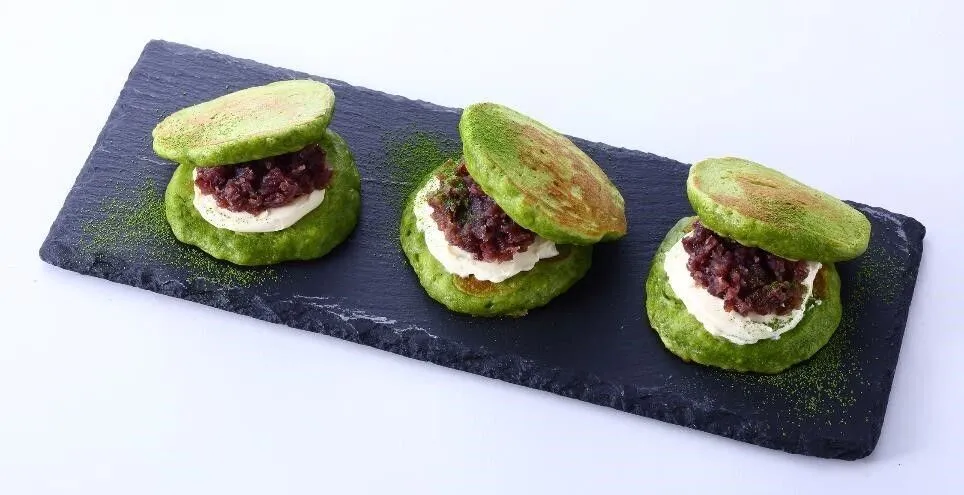 ③につぶあんとクリームチーズをはさみ、抹茶（分量外）をふる。