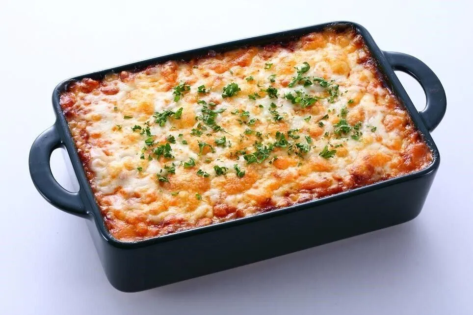 耐熱性の器に②の1/4量、餅6枚、③の1/3量を順に広げ入れてこれを繰り返す。ピザ用チーズを散らしてオーブントースターで約15分焼き、竹串をさして餅がやわらかかったら取り出し、パセリを散らす。