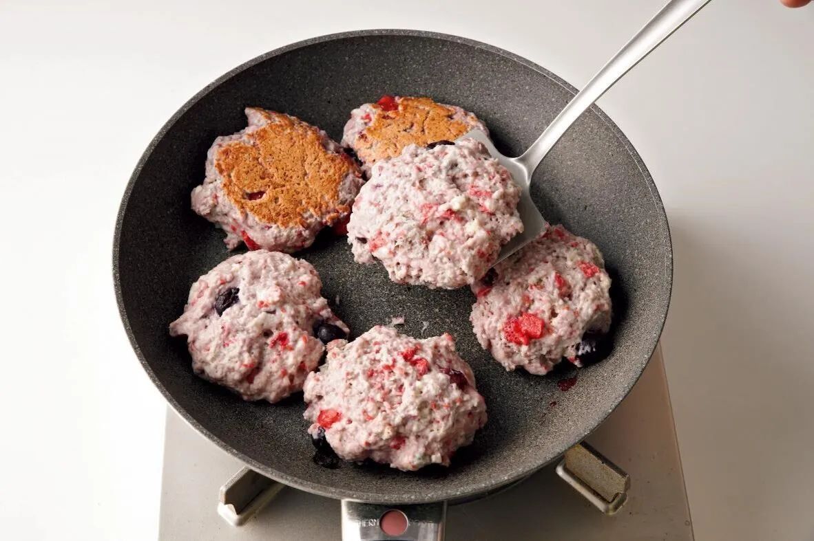 フライパンを中火にかけて3分熱し、ぬれぶきんにのせていったんさます。サラダ油を薄く塗り、1を並べ入れる。ふたをして弱火にし、9分焼く。上下を返して再びふたをし、さらに9分焼く。

（画像：上下をかえす。）