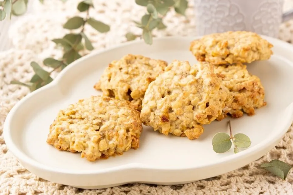 オーブン用シートを敷いた天板にスプーンで生地を落とし、約5cmに広げて成形し、オーブンで約15分焼く。