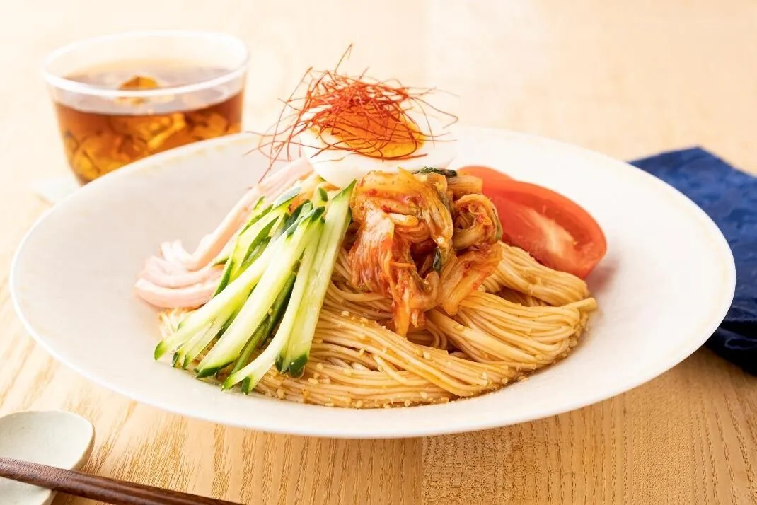 器に盛り、トマト、きゅうり、ハム、キムチ、ゆで卵をのせる。すり白ごまをふり、糸唐辛子をのせる。