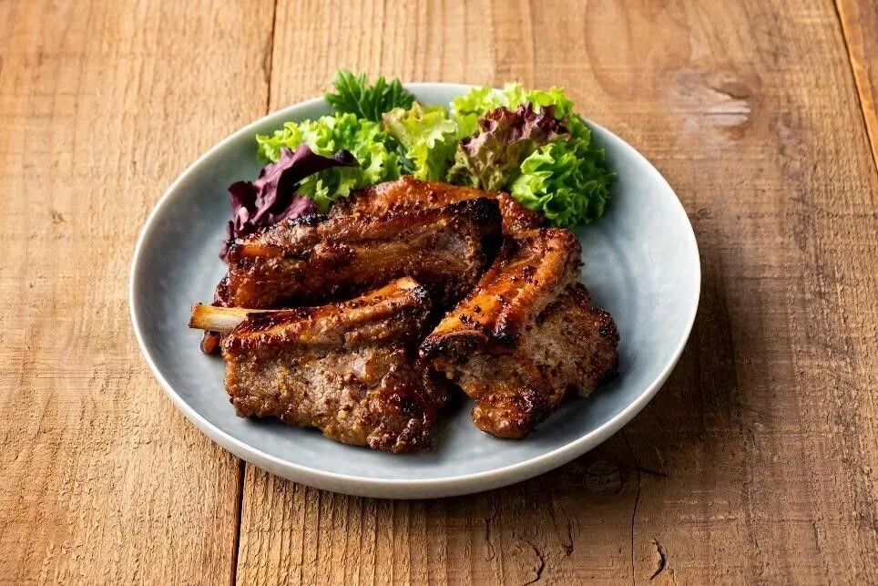 オーブン用シートを天板に敷き、スペアリブを並べる。漬け汁をかけ、200℃に予熱したオーブンで約25分焼く。