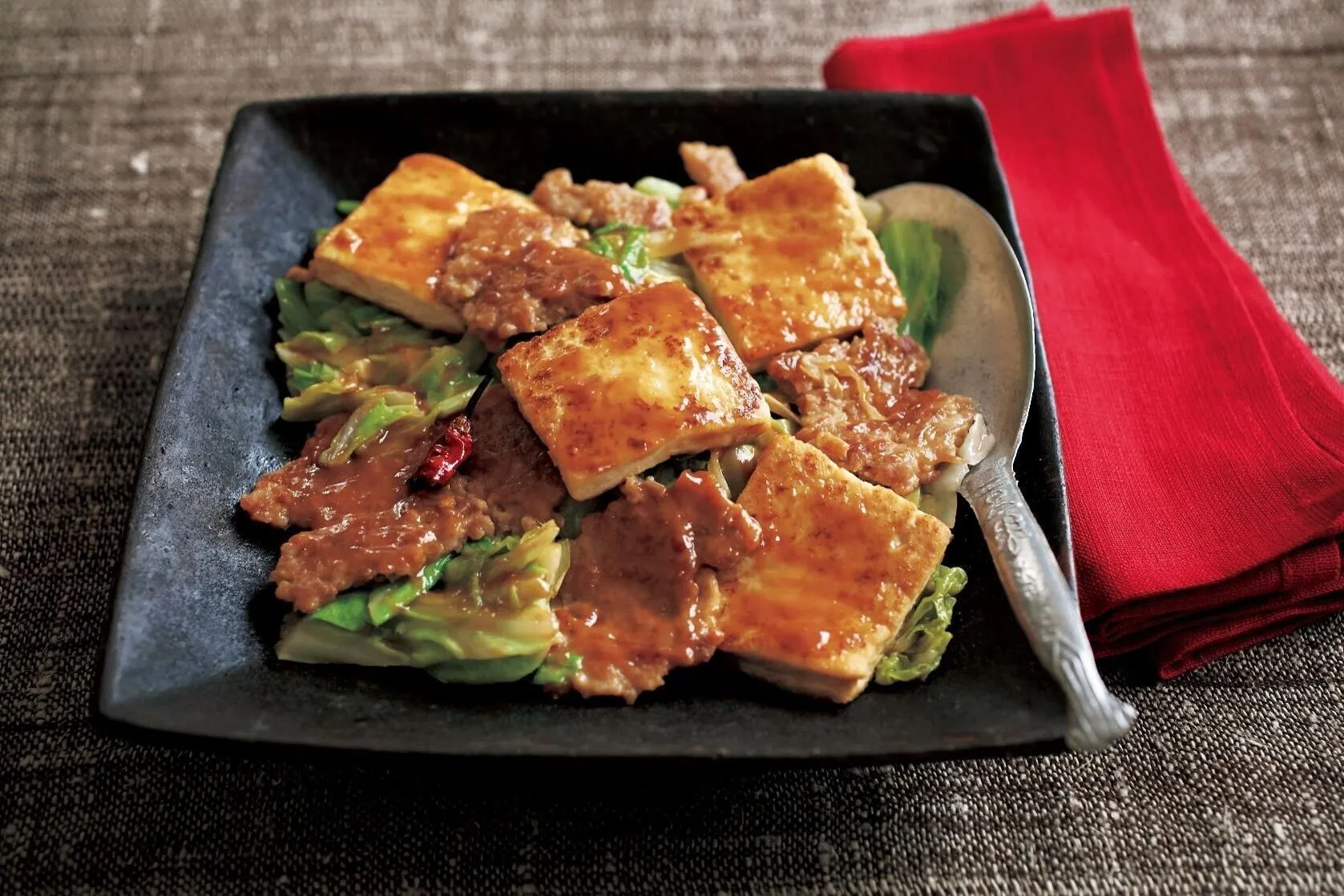 同じフライパンにごま油大さじ1/2を加え、キャベツ、赤唐辛子を加えて1分ほど炒める。豆腐、でかそぼろを戻し入れ、Bのたれを加えてざっと炒め合わせる。