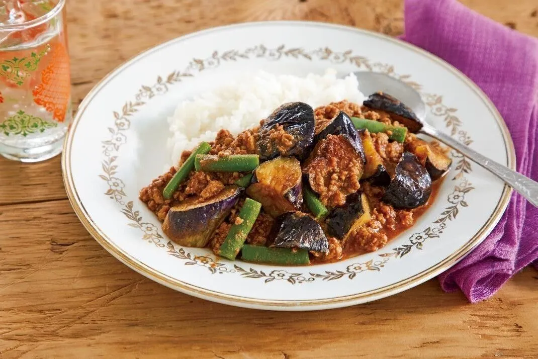 同じフライパンにバターを中火で熱し、ひき肉を炒める。ぱらぱらになったらカレー粉を加えて炒める。香りが立ったらトマトのすりおろし、ケチャップ、ウスターソース、塩、こしょうを加えて混ぜ、5～6分煮る。なすを戻し入れていんげんを加え、3～4分煮る。