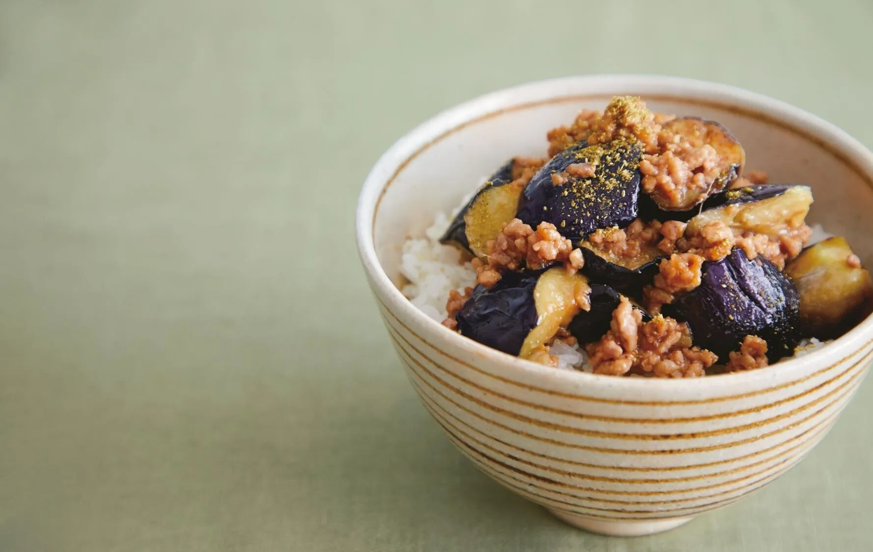 器にご飯を盛ってなすとひき肉をのせ、好みで粉山椒をかけたら「なすと豚ひき肉のみそ炒め丼」の完成です。