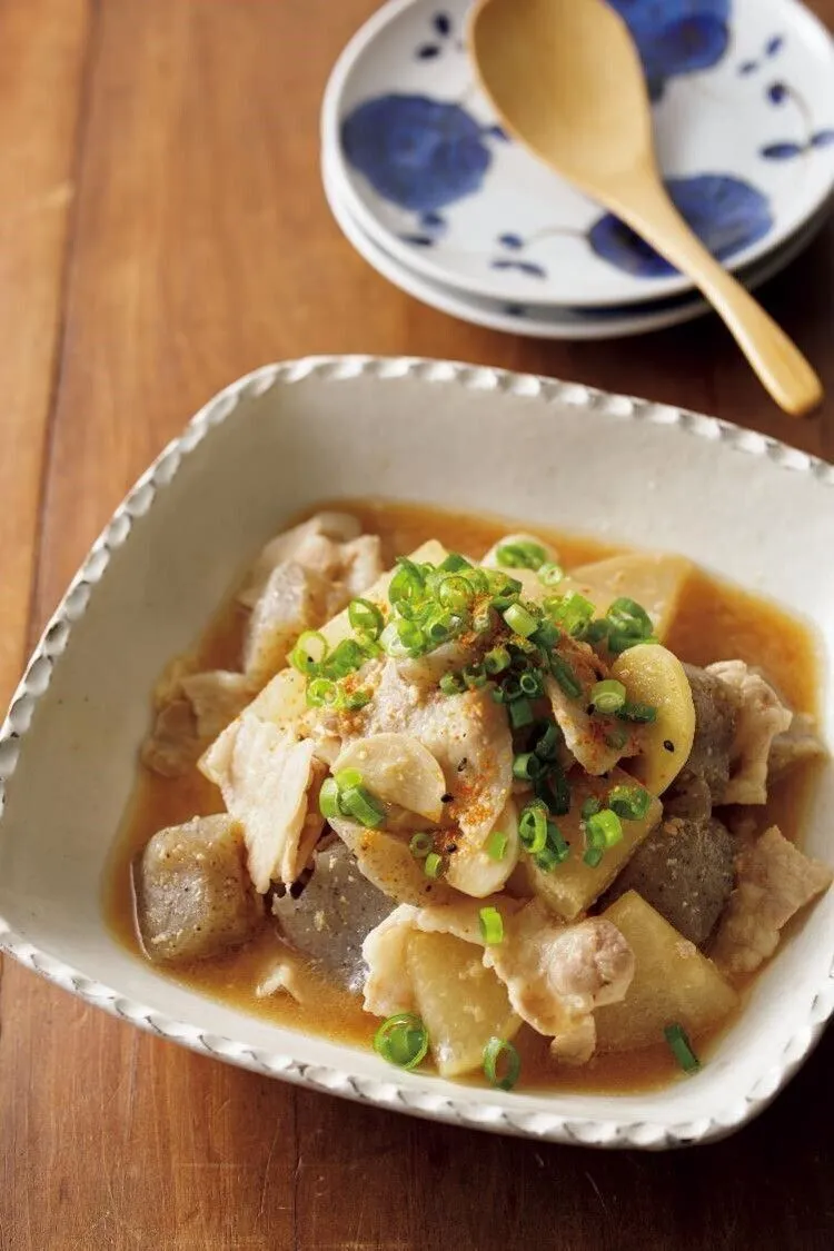 直径24cmのフライパンに水2カップ、酒、塩、大根、こんにゃく、にんにく、しょうがを入れて中火で煮立て、ふたをして5～6分煮る。豚肉を加え、さっと煮てアクを取り、みそを溶き入れて2分煮る。器に盛り、万能ねぎ、七味唐辛子をふる。