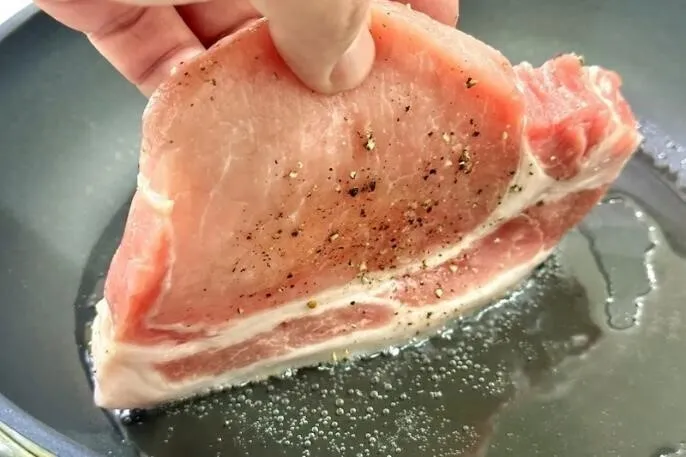 フライパンに油をひき、弱めの中火にかける。肉を脂身が下になるように立てて、約3分焼く。