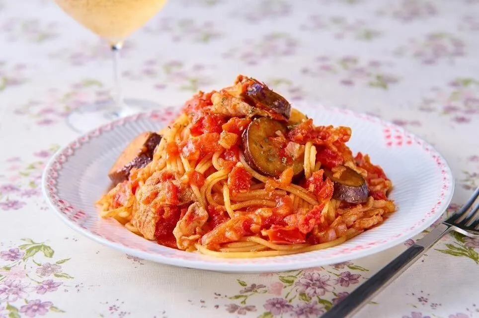 茹で上がったパスタにトマトソースを絡め、バジルを散らす。