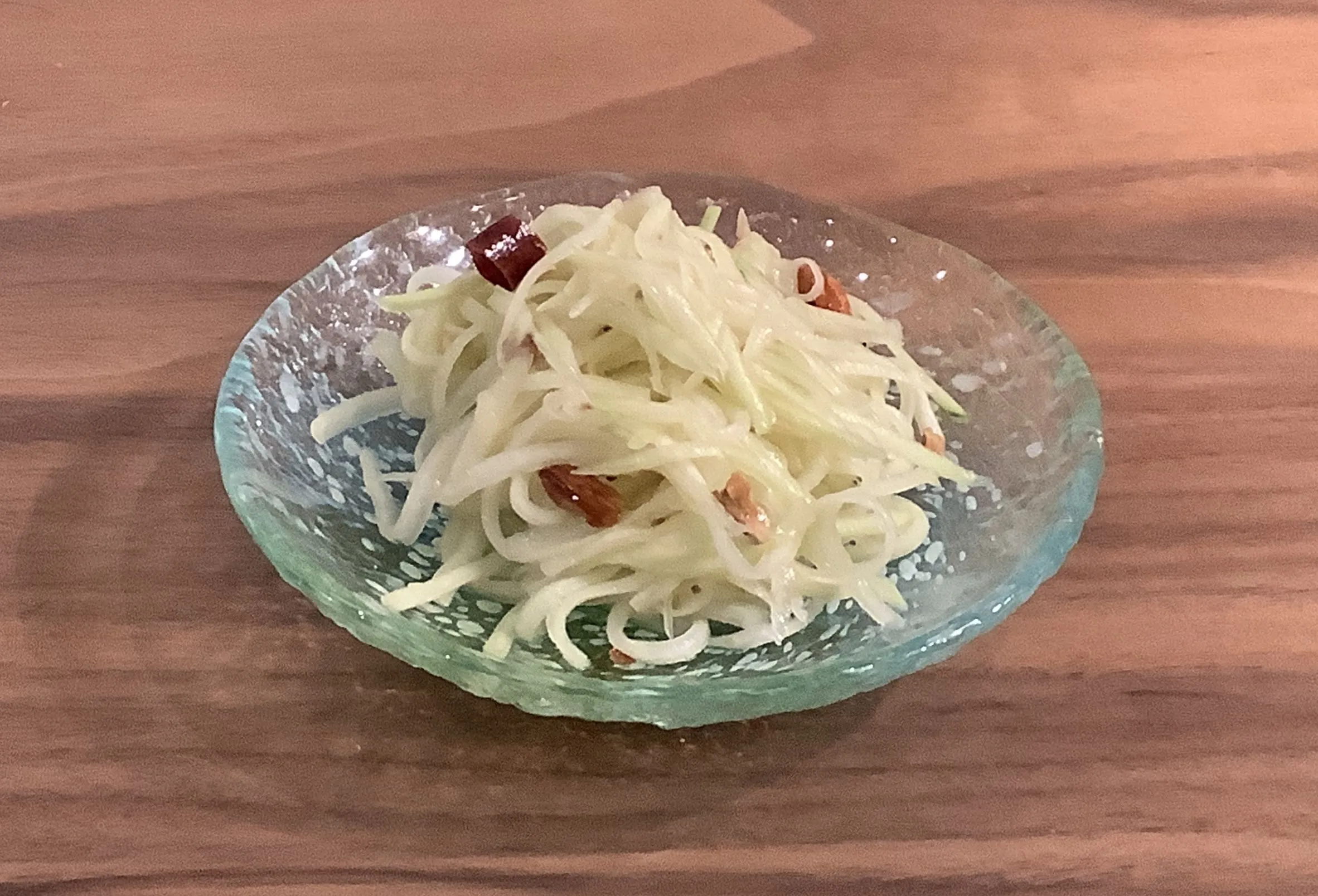 青パパイヤの水を切り、3を混ぜ合わせます。適量のこしょうを振って青パパイヤのサラダの完成。